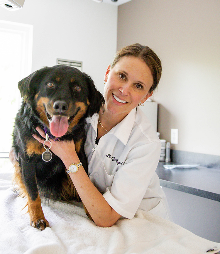 Dr. Cynthia Sagel posing with a black dog